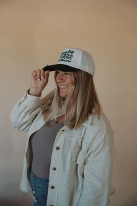 side view of model wearing the never be the same shacket. model has the shacket paired with the change your mind bodysuit in the color smoky taupe and the country and western trucker hat.