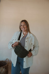 front view of model wearing the it girl crossbody in the color olive. model has the bag paired with the never be the same shacket and the change your mind bodysuit in the color smoky taupe.