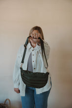 Load image into Gallery viewer, front view of model holding the it girl crossbody in the color olive. model has the bag paired with the never be the same shacket and the change your mind bodysuit in the color smoky taupe.