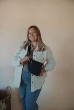 Load image into Gallery viewer, front view of model wearing the it girl crossbody in the color navy. model has the bag paired with the never be the same shacket and the change your mind bodysuit in the color smoky taupe.