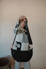 Load image into Gallery viewer, front view of model holding the it girl crossbody in the color black. model has the bag paired with the where you are sweater and the siena denim.