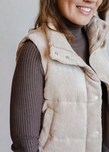 model wearing the what could have been vest in the color khaki. model has the vest paired with the can't get enough top in the color brown and a pair of dark wash jeans.