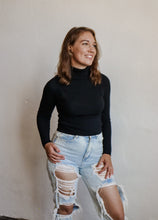 Load image into Gallery viewer, model wearing the can&#39;t get enough top in the color black. model has the top paired with a pair of light wash, distressed denim
