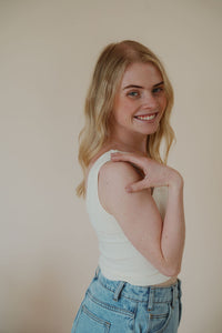 side view of model wearing the stay the same top in the color cream. model has the top paired with the dakota denim shorts.