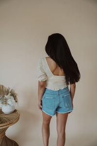 back view of model wearing the note to self top. model has the top paired with the boston denim shorts.