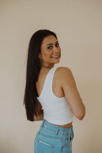 side view of model wearing the stay the same top in the color white. model has the top paired with the boston denim shorts.