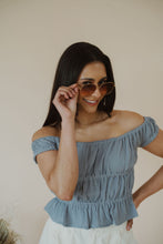 Load image into Gallery viewer, model wearing the lea sunglasses in the color gold/brown.