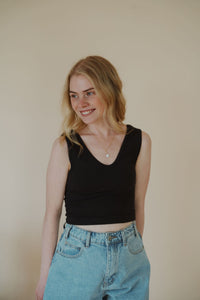 front view of model wearing the stay the same top in the color black. model has the top paired with the dakota denim shorts.