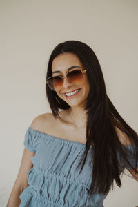 model wearing the lea sunglasses in the color gold/brown.