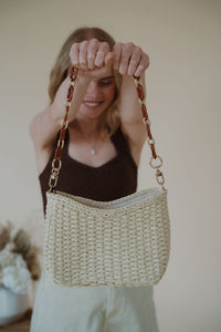 model holding the weekend getaway bag in the color cream.
