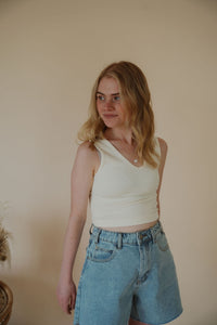 front view of model wearing the stay the same top in the color cream. model has the top paired with the dakota denim shorts.