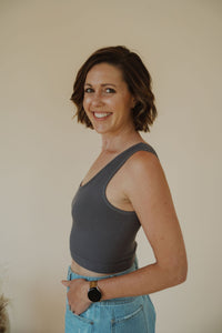side view of model wearing the stay the same top in the color charcoal. model has the top paired with the boston denim shorts.