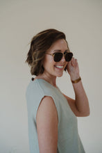 Load image into Gallery viewer, model wearing the lea sunglasses in the color gold/black.