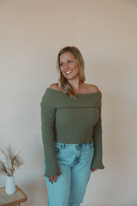 front view of model wearing the love somebody sweater in the color olive. model has the sweater paired with the charleston denim.