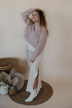 Load image into Gallery viewer, side view of model wearing the cherish satin maxi in the color ivory. model has the skirt paired with the devoted sweater.