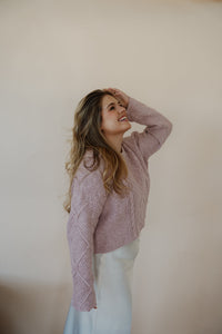 side view of model wearing the devoted sweater. model has the sweater paired  with the cherish satin maxi in the color ivory.