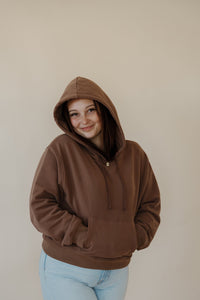 front view of model wearing the something more sweatshirt in the color chocolate. model has the sweatshirt paired with the camden denim.