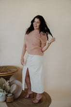 Load image into Gallery viewer, front view of model wearing the all over again denim midi skirt. model has the skirt paired with the nothing to prove top in the color dusty pink.