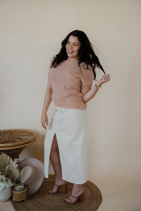 front view of model wearing the all over again denim midi skirt. model has the skirt paired with the nothing to prove top in the color dusty pink.