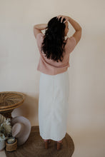 Load image into Gallery viewer, back view of model wearing the all over again denim midi skirt. model has the skirt paired with the nothing to prove top in the color dusty pink.