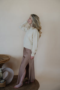 side view of model wearing the cherish satin maxi in the color mauve. model has the skirt paired with the sunday matinee sweater.