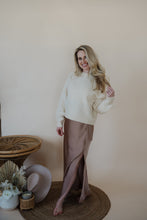 Load image into Gallery viewer, front view of model wearing the cherish satin maxi in the color mauve. model has the skirt paired with the sunday matinee sweater.