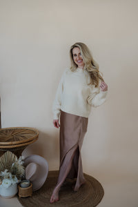 front view of model wearing the cherish satin maxi in the color mauve. model has the skirt paired with the sunday matinee sweater.
