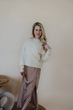 Load image into Gallery viewer, front view of model wearing the cherish satin maxi in the color mauve. model has the skirt paired with the sunday matinee sweater.