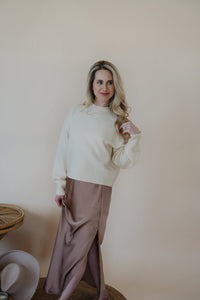 front view of model wearing the cherish satin maxi in the color mauve. model has the skirt paired with the sunday matinee sweater.