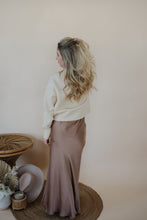 Load image into Gallery viewer, back view of model wearing the cherish satin maxi in the color mauve. model has the skirt paired with the sunday matinee sweater.