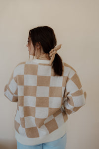 back view of model wearing the new beginnings sweater. model has the sweater paired with the Camden denim + an EBNS mini scrunchie scarf.