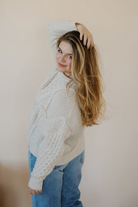 side view of model wearing the my way back home sweater in the color ivory. model has the sweater paired with the Hartford denim.