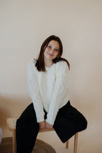 Load image into Gallery viewer, front view of model wearing the somewhere in the middle sweater in the color ivory. model has the sweater paired with the addison denim in the color fade black.
