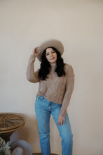 Load image into Gallery viewer, front view of model wearing the somewhere in the middle sweater in the color oat. model has the sweater paired with the Hartford denim.