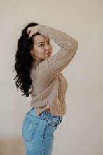Load image into Gallery viewer, side view of model wearing the somewhere in the middle sweater in the color oat. model has the sweater paired with the Hartford denim.