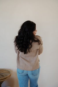 back view of model wearing the somewhere in the middle sweater in the color oat. model has the sweater paired with the Hartford denim.