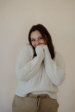 Load image into Gallery viewer, front view of model wearing the every moment sweater in the color ivory. model has the sweater paired with the in another life skirt.