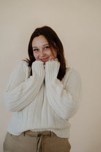 Load image into Gallery viewer, front view of model wearing the every moment sweater in the color ivory. model has the sweater paired with the in another life skirt.