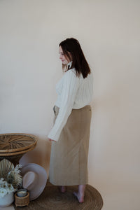 back view of model wearing the every moment sweater in the color ivory. model has the sweater paired with the in another life skirt.