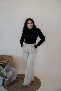 front view of model wearing the Oakland chinos. model has the chinos paired with the after all top in the color black.