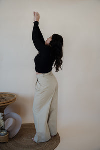 back/side view of model wearing the Oakland chinos. model has the chinos paired with the after all top in the color black.