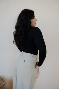 back view of model wearing the after all top in the color black. model has the top paired with the Oakland chinos.