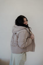 Load image into Gallery viewer, side view of model wearing the where it all began puffer in the color khaki. model has the puffer paired with the all along top in the color black and the oakland chinos.