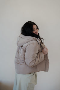 side view of model wearing the where it all began puffer in the color khaki. model has the puffer paired with the all along top in the color black and the oakland chinos.