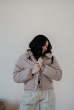 Load image into Gallery viewer, front view of model wearing the where it all began puffer in the color khaki. model has the puffer paired with the all along top in the color black and the oakland chinos.