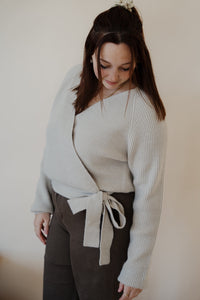 side view of model wearing the when you were mine sweater in the color oatmeal. model has the sweater paired with the Addison denim in the color brown.