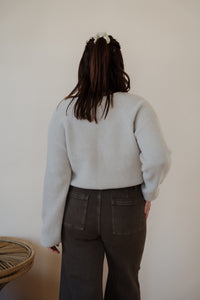 back view of model wearing the Addison denim in the color brown. model has the denim paired with the when you were mine sweater in the color oatmeal.