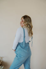 Load image into Gallery viewer, side view of model wearing the clara denim jumpsuit in denim.