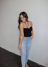 Load image into Gallery viewer, model wearing the think of me top in the color black. model has the top paired with a pair of light wash denim.