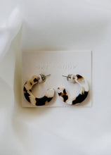 Load image into Gallery viewer, felicity hoop earrings in the color coco cream. earrings are shown on an earring card laid on top of a white sheet.